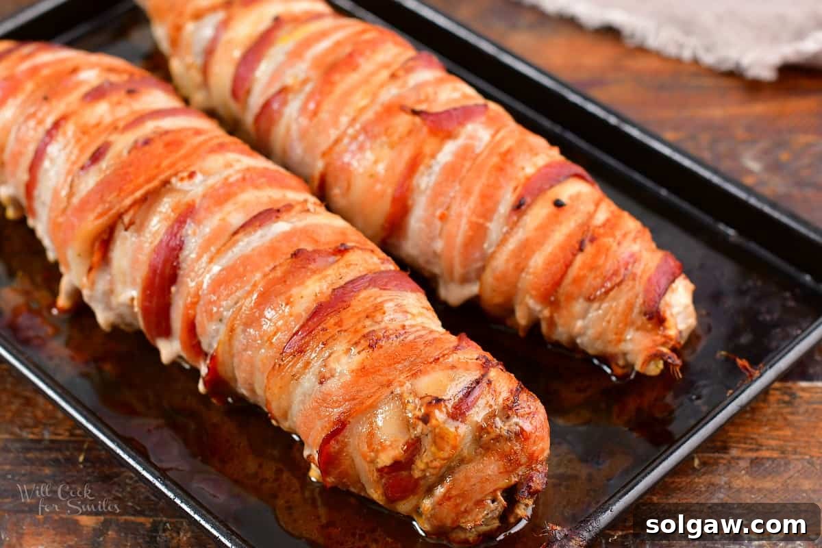 stuffed pork tenderloin in bacon cooked on black sheet pan
