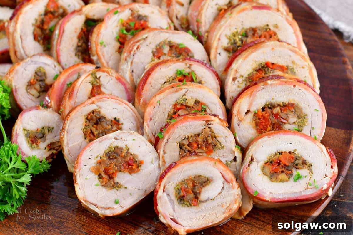 sliced stuffed pork tenderloin spread in a large wooden platter