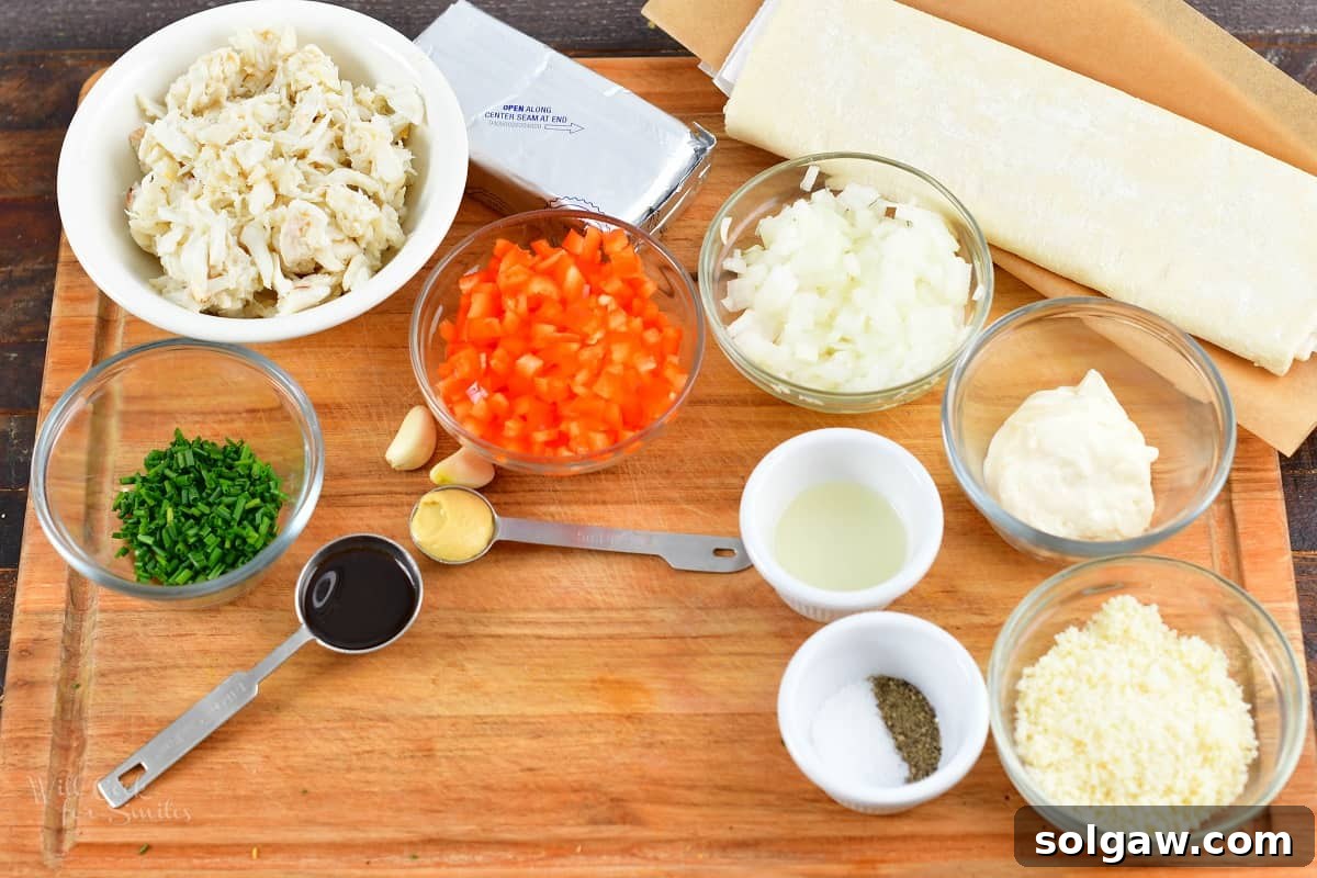 A vibrant array of fresh ingredients laid out, including softened cream cheese, mayonnaise, parmesan cheese, lump crab meat, diced onion, red bell pepper, minced garlic, chives, Worcestershire sauce, Dijon mustard, and lemon, ready to be combined for the delicious crab puff filling.