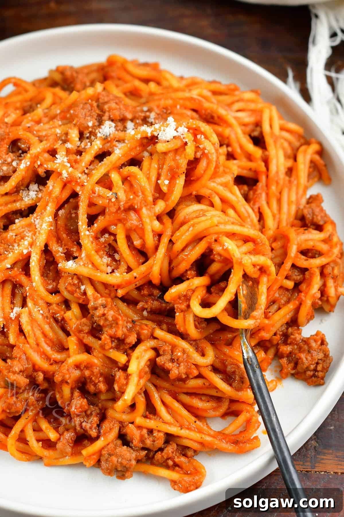 closeup of pasta with sauce and swirled on a fork