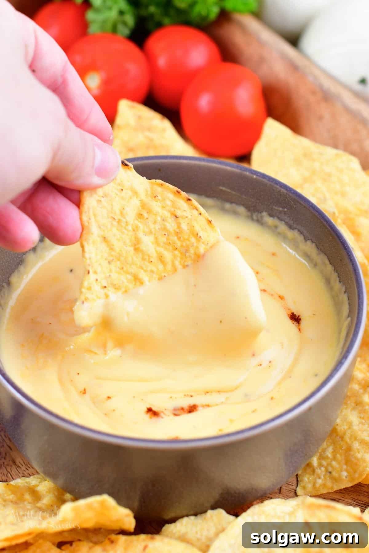 scooping some nacho cheese with a tortilla chip