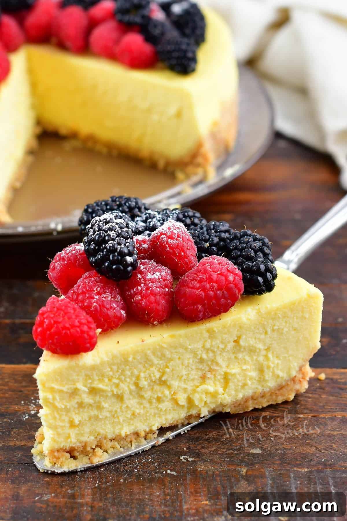 A delectable slice of homemade ricotta cheesecake, elegantly topped with fresh mixed berries, showcasing its creamy texture and golden crust.