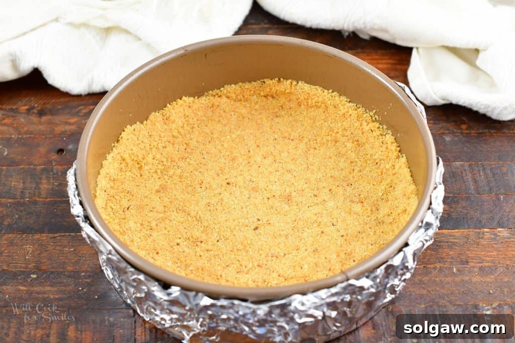 A perfectly pressed biscotti crust lining the bottom and sides of a springform pan, ready for the filling.