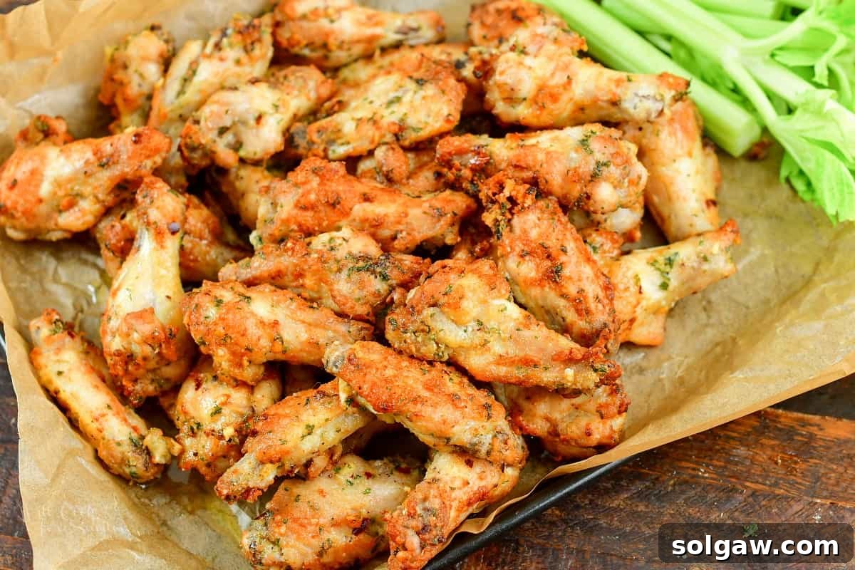 Crispy Air Fryer Garlic Parmesan Wings 5 Crispy air fryer chicken wings served on parchment paper, ready to be enjoyed.