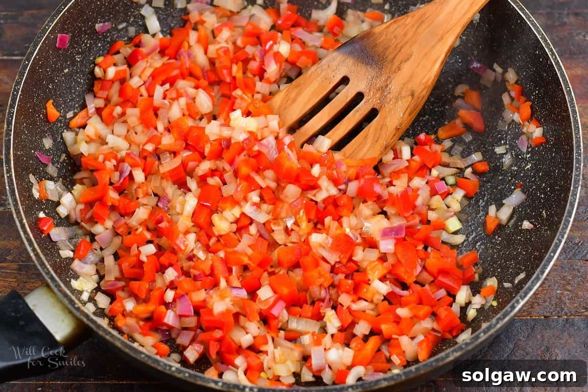 sautéing onions and peppers in a pan