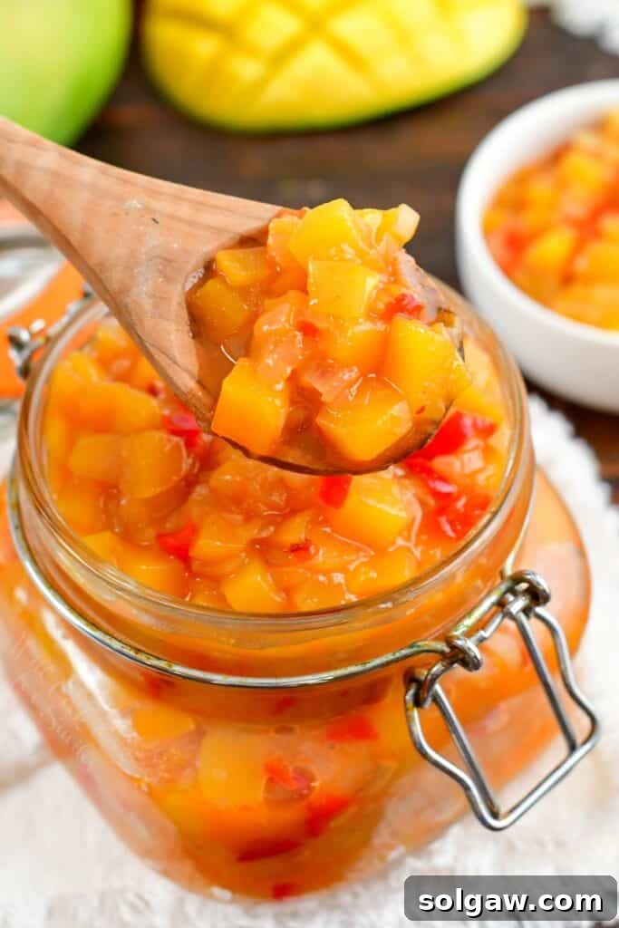 spooning some mango chutney from a bar