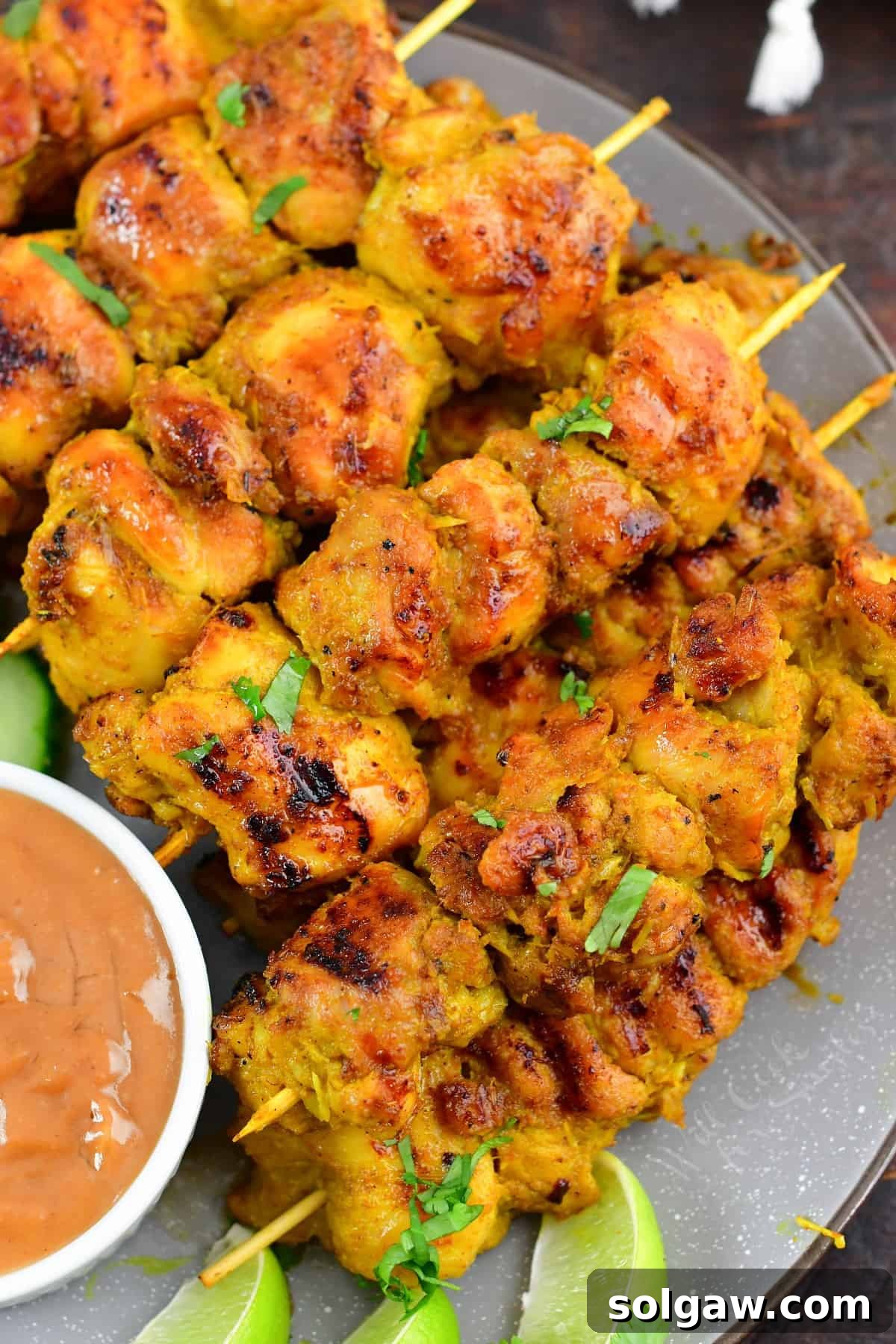 Sizzling Thai Chicken Satay with Velvety Peanut Sauce 7 closeup of several skewers of chicken satay stacked