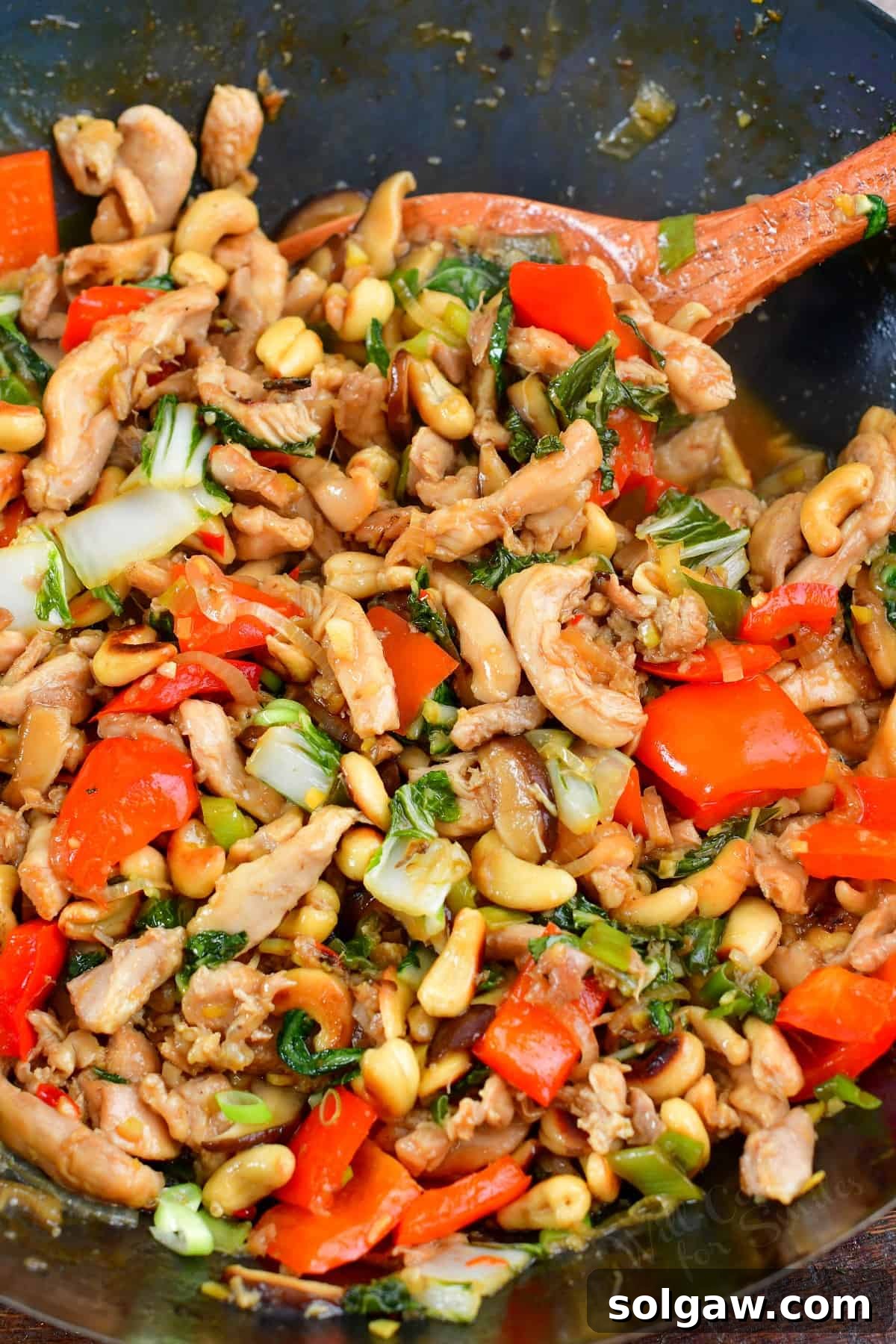 A vibrant bowl of Thai Cashew Chicken (Gai Pad Med Mamuang) garnished with fresh herbs, ready to be enjoyed.
