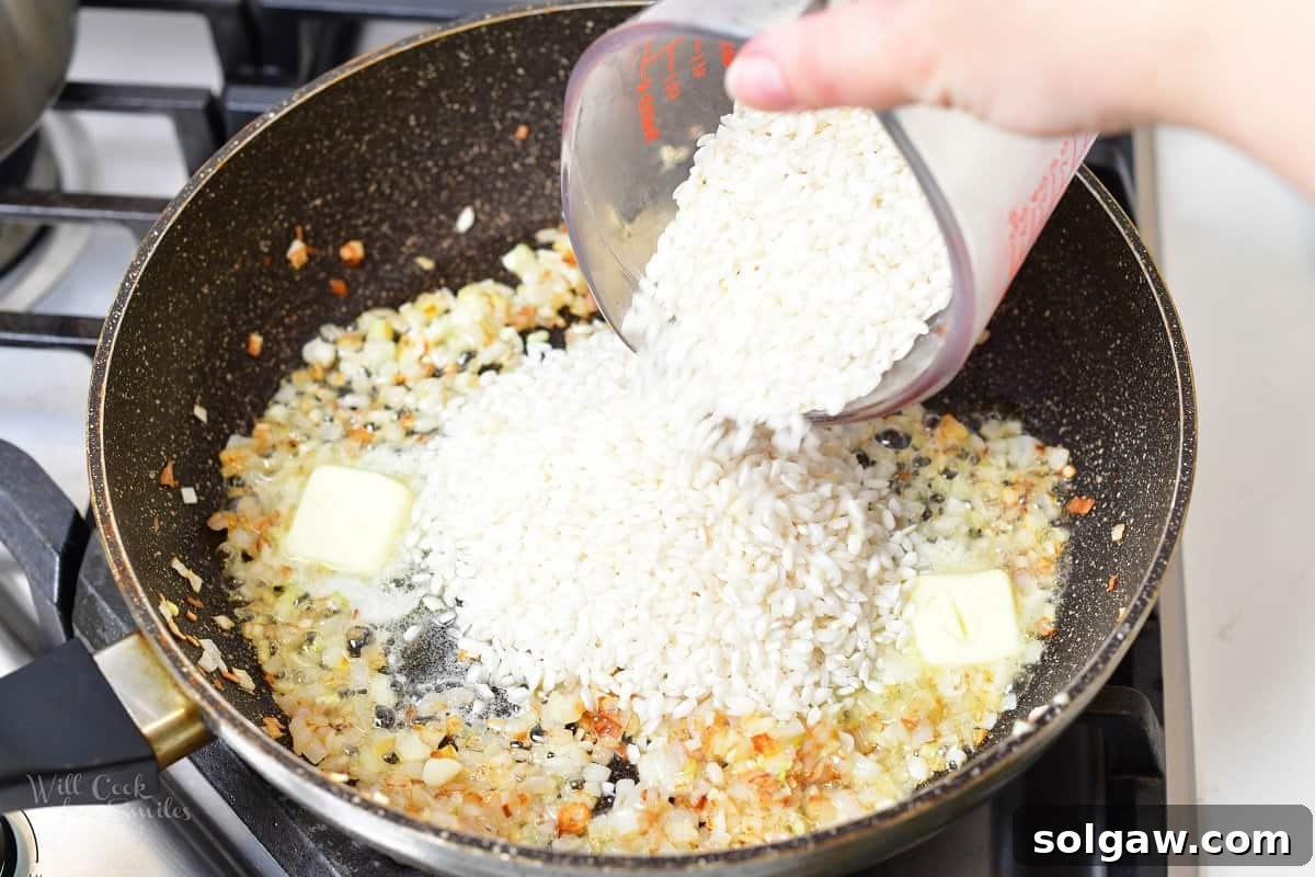 A close-up of a skillet with shallots sautéing in butter, the initial step for making creamy lemon risotto.