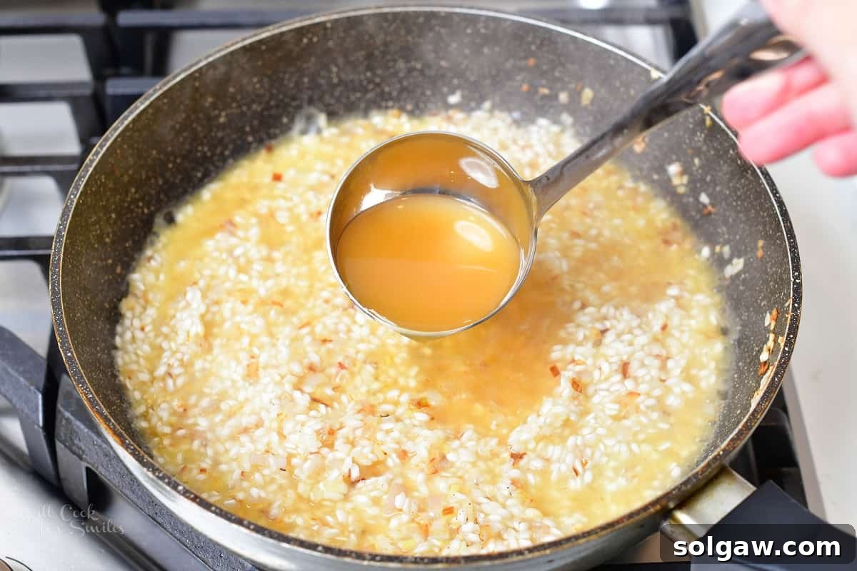 White wine being poured over Arborio rice in a pan, ready to be absorbed into the developing risotto.