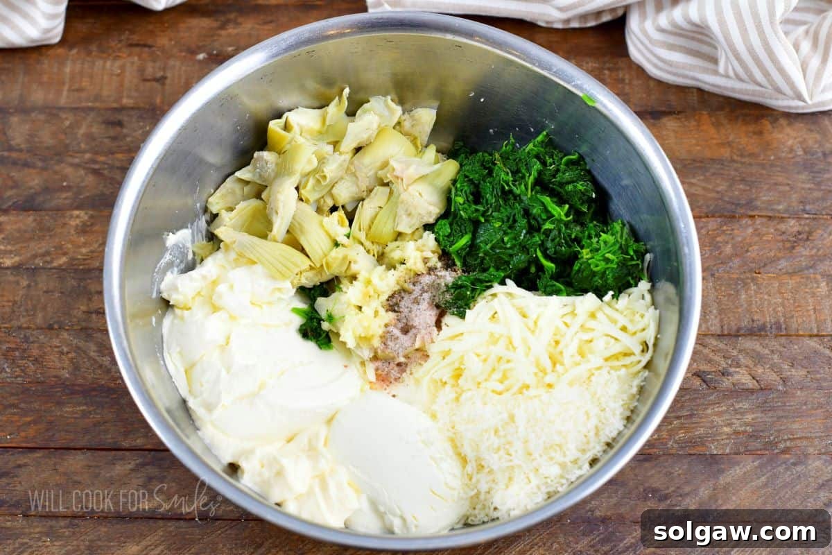 A vibrant array of fresh ingredients for spinach artichoke dip being carefully added to a large, clear mixing bowl, ready for combination.