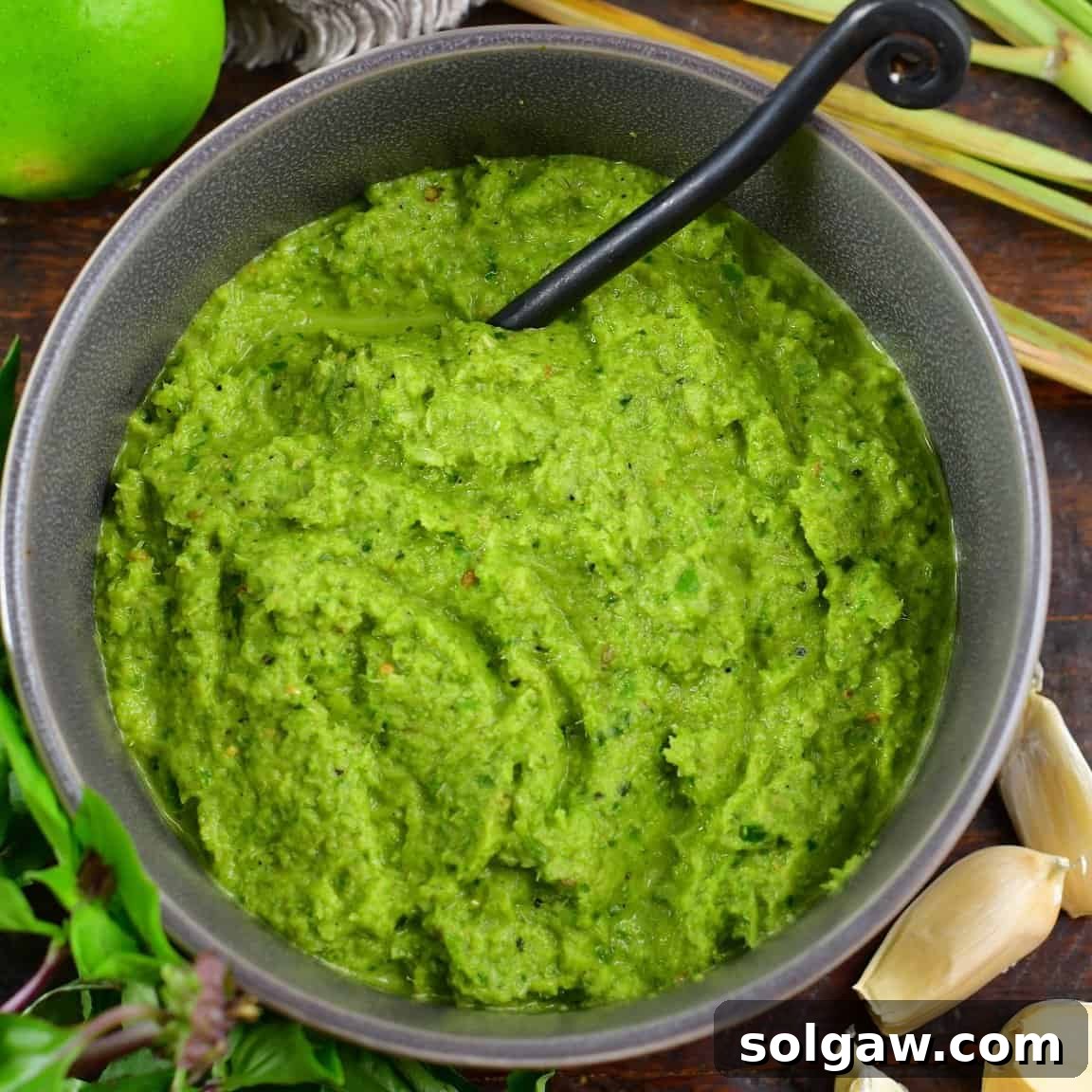 squared off image of green curry in a bowl in the center