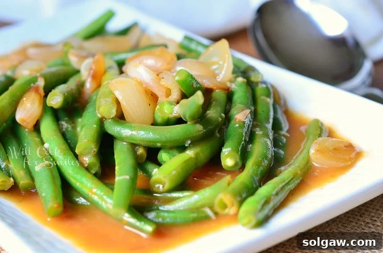 Close-up of French Green Beans with caramelized pearl onions, perfectly sauced and ready for the holiday table.