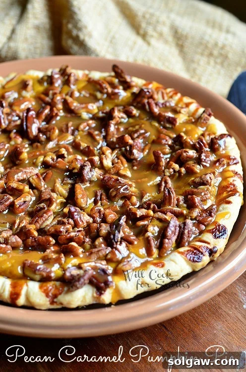 Decadent Pecan Caramel Pumpkin Pie 6 The full Pecan Caramel Pumpkin Cheesecake Pie in a brown pie pan, ready to be served.