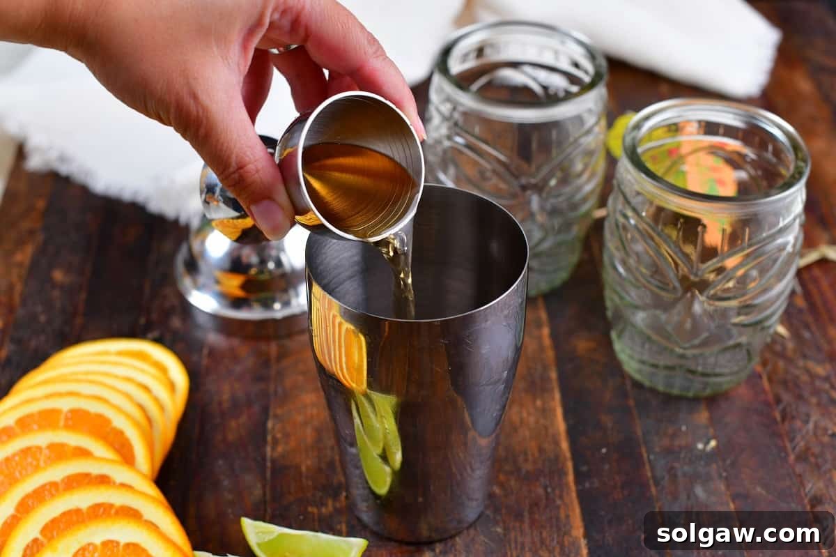 Pouring peach schnapps into a cocktail shaker, adding a sweet and fruity note to the Calypso Cooler ingredients.