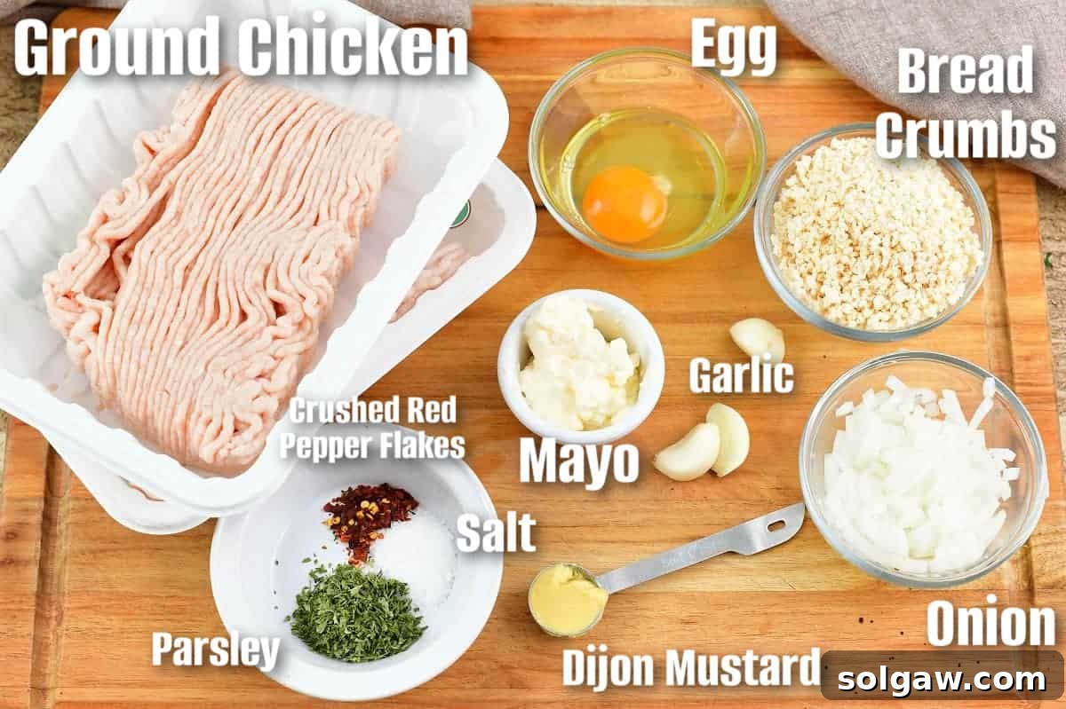 labeled ingredients to make chicken meatballs on the cutting board, showing fresh herbs, ground chicken, and other components.