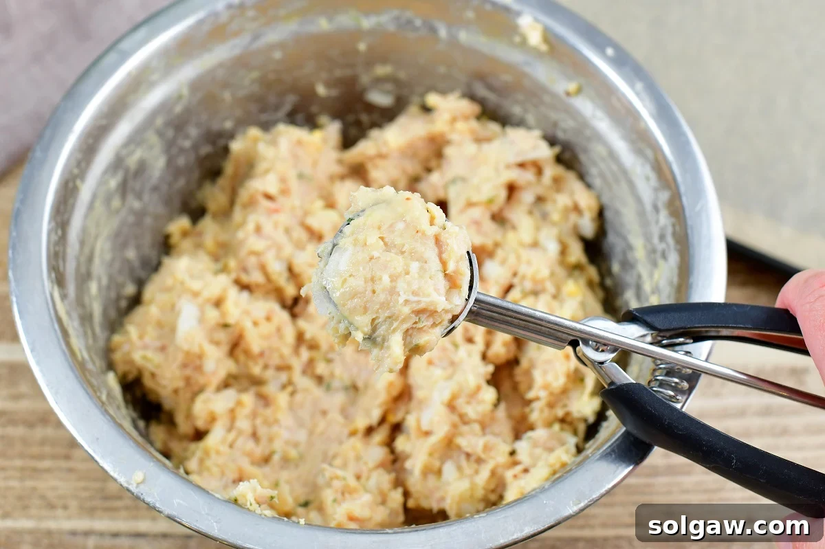 scooping chicken mixture with a #40 scoop into uniform balls