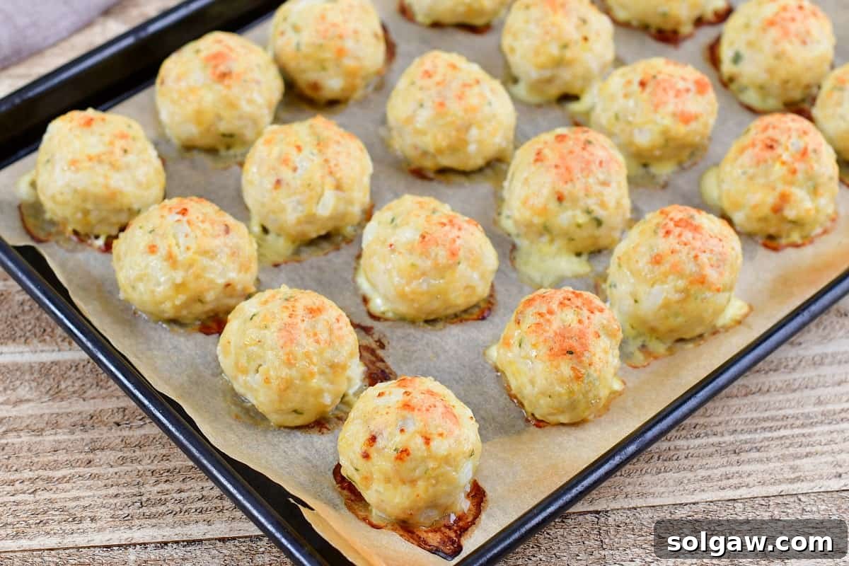 baked chicken meatballs perfectly golden brown on a baking sheet