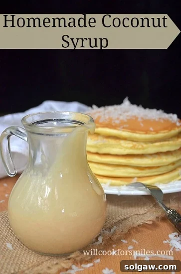 coconut syrup in a pitcher with coconut pancakes in the background