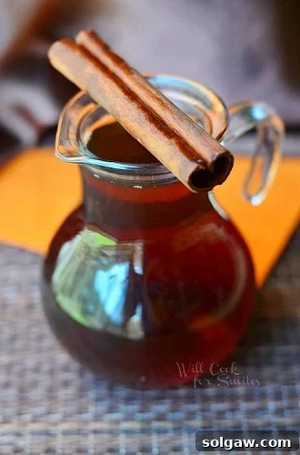 Cinnamon Dolce syrup in a glass serving container with a cinnamon stick across it