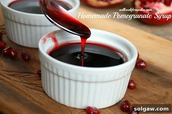Pomegranate syrup in a bowl with a spoon pouring some in on a wood cutting board
