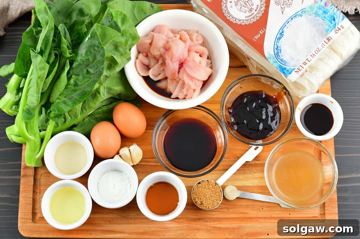 Fresh ingredients for making Pad See Ew laid out on a wooden cutting board, including wide rice noodles, Chinese broccoli, and various sauces.