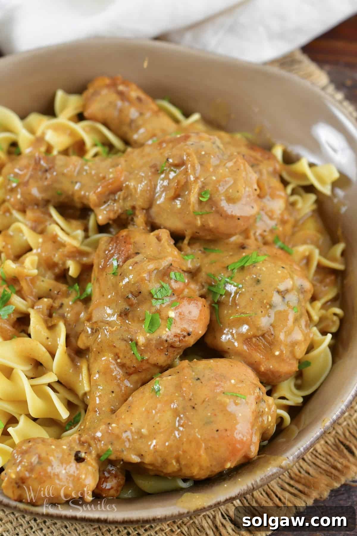 top view of chicken legs in sauce over egg noodles