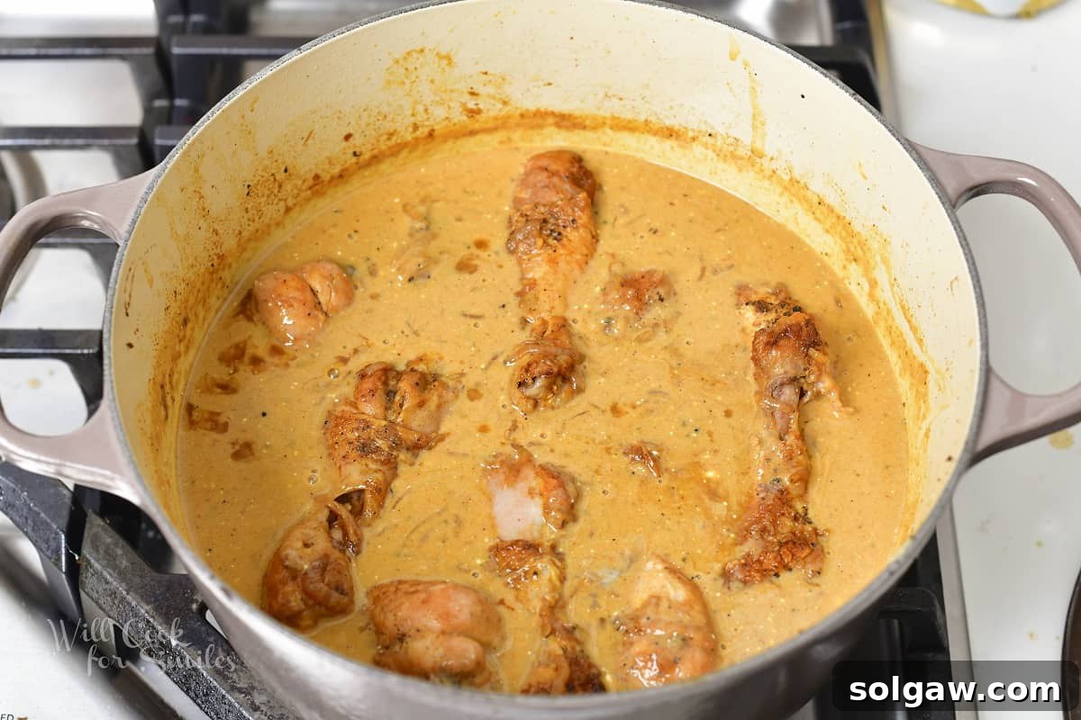 cooked chicken drumsticks in a creamy brown sauce