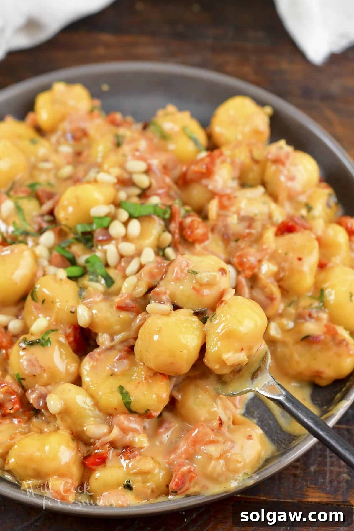 scooping some creamy gnocchi from the plate