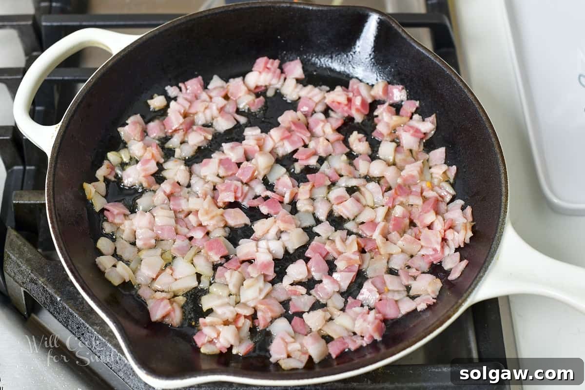 Sautéing diced pancetta in a hot pan until crispy and golden brown.
