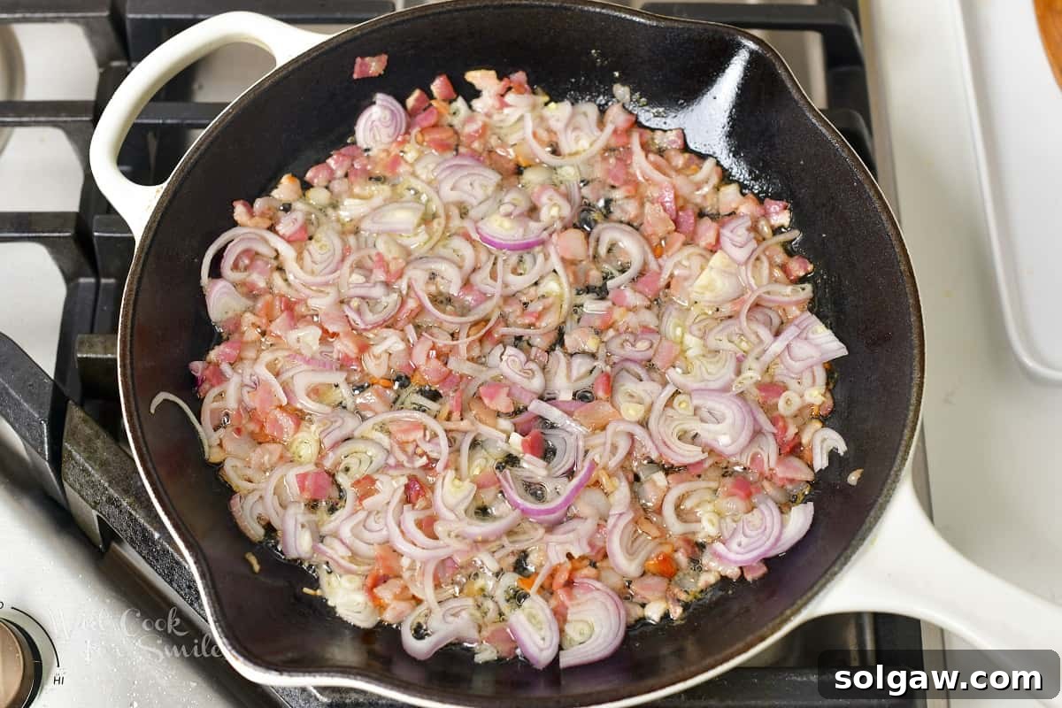 Sautéing diced pancetta with finely chopped shallots in a pan, releasing their aromatic flavors.