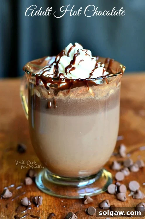 Adult Hot Chocolate in a glass topped with whipped cream and chocolate sauce
