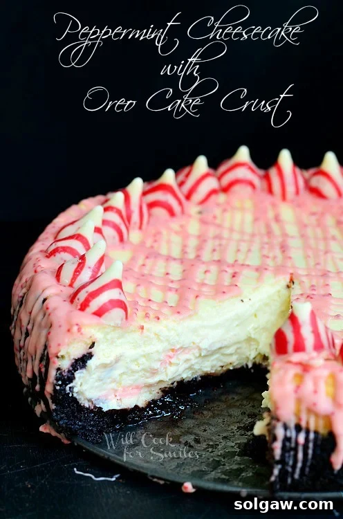 Oreo Crunch Peppermint Cheesecake 2 Peppermint Cheesecake with peppermint kisses along the outside and with Oreo Cake Crust with a slice out of it