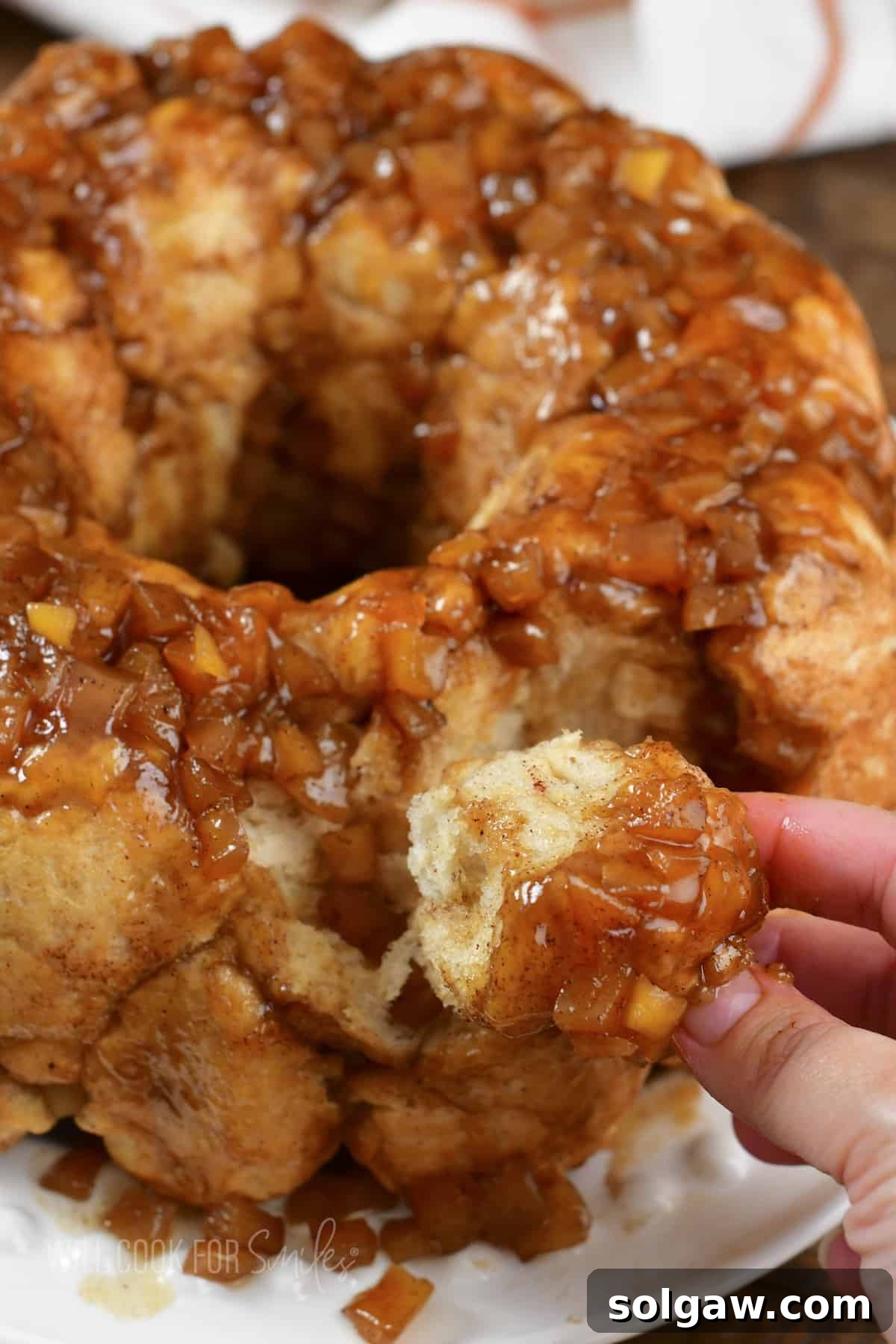 Closeup of pulling off a piece of apple pie monkey bread.