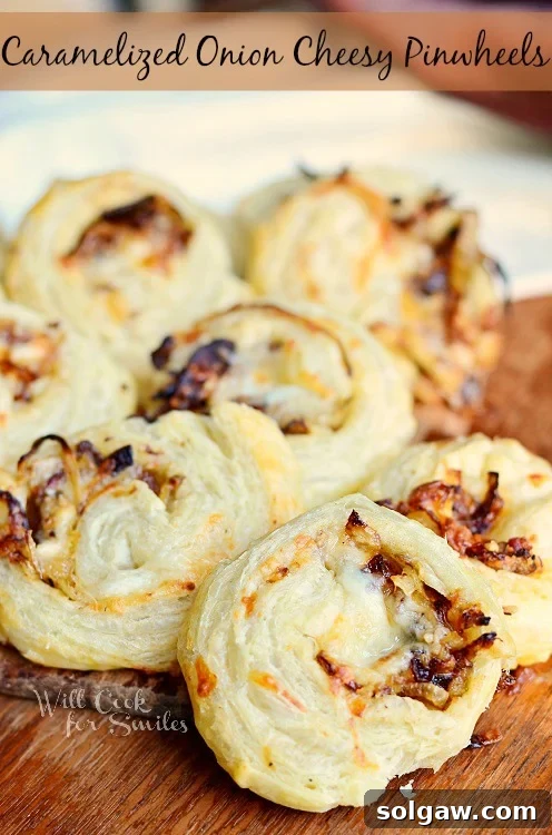 Golden Caramelized Onion Cheese Swirls 2 Caramelized Onion Cheesy Pinwheels on a cutting board, perfectly golden and flaky.