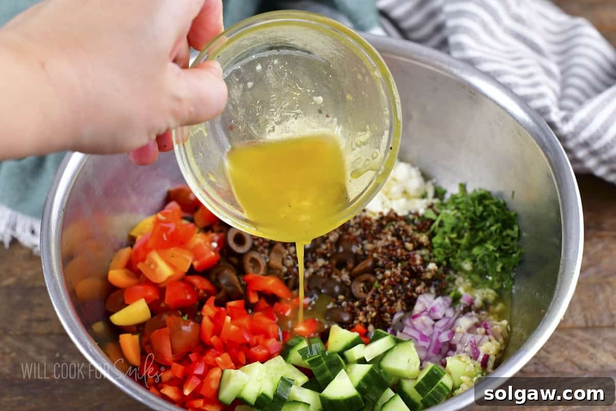 Sun-Kissed Quinoa and Feta Salad 4 adding Greek dressing to the quinoa salad ingredients.