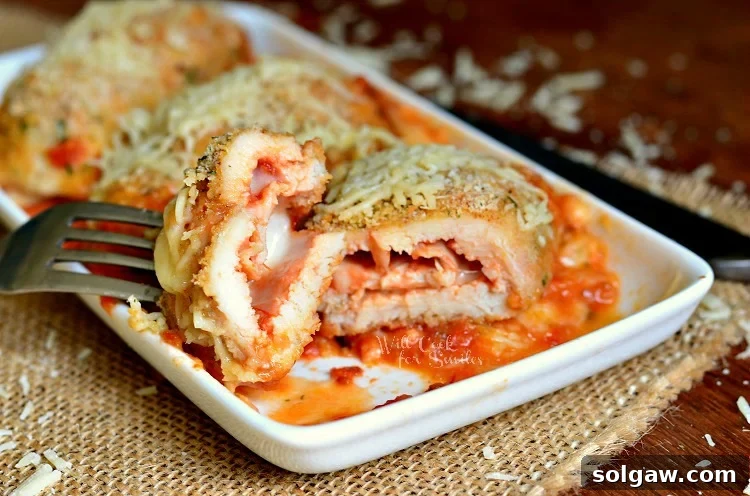 Close up of a cut Chicken Parmesan Roll Up showing the gooey mozzarella and marinara