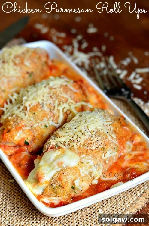 Chicken Parmesan Roll Ups in a white serving tray on a table with a fork to the right
