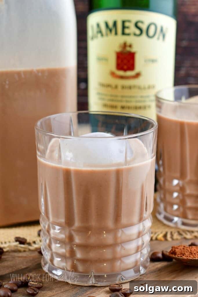 closeup on one rocks glass with Irish cream with ice cube.