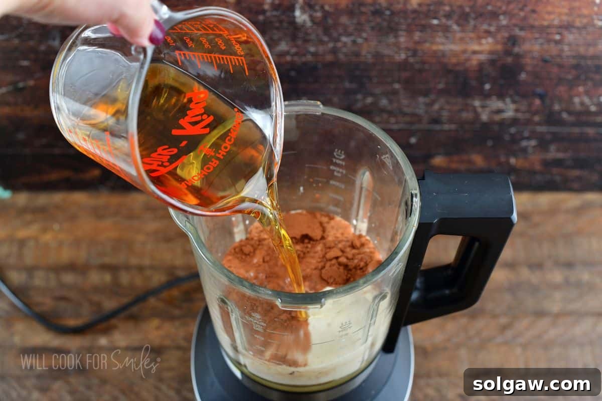 pouring Irish whiskey into the blender.