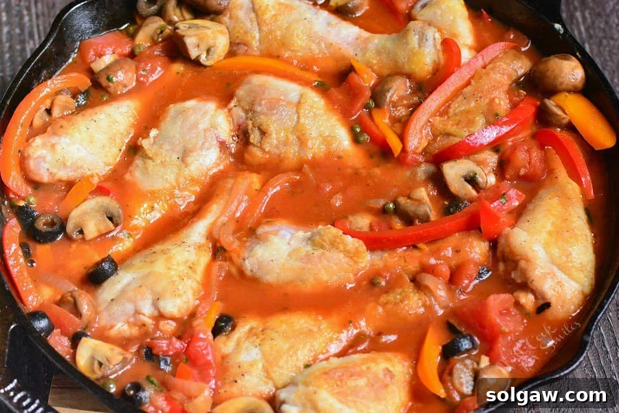 Chicken Cacciatore simmering in a pan with vegetables and sauce