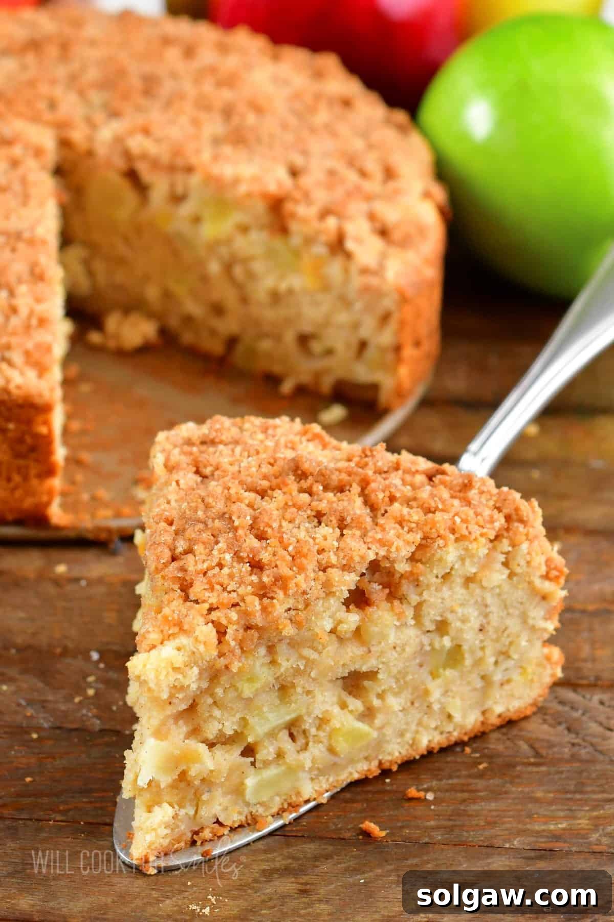 Closeup of a delectable slice of Irish apple cake with its signature streusel topping and visible chunks of spiced apple.