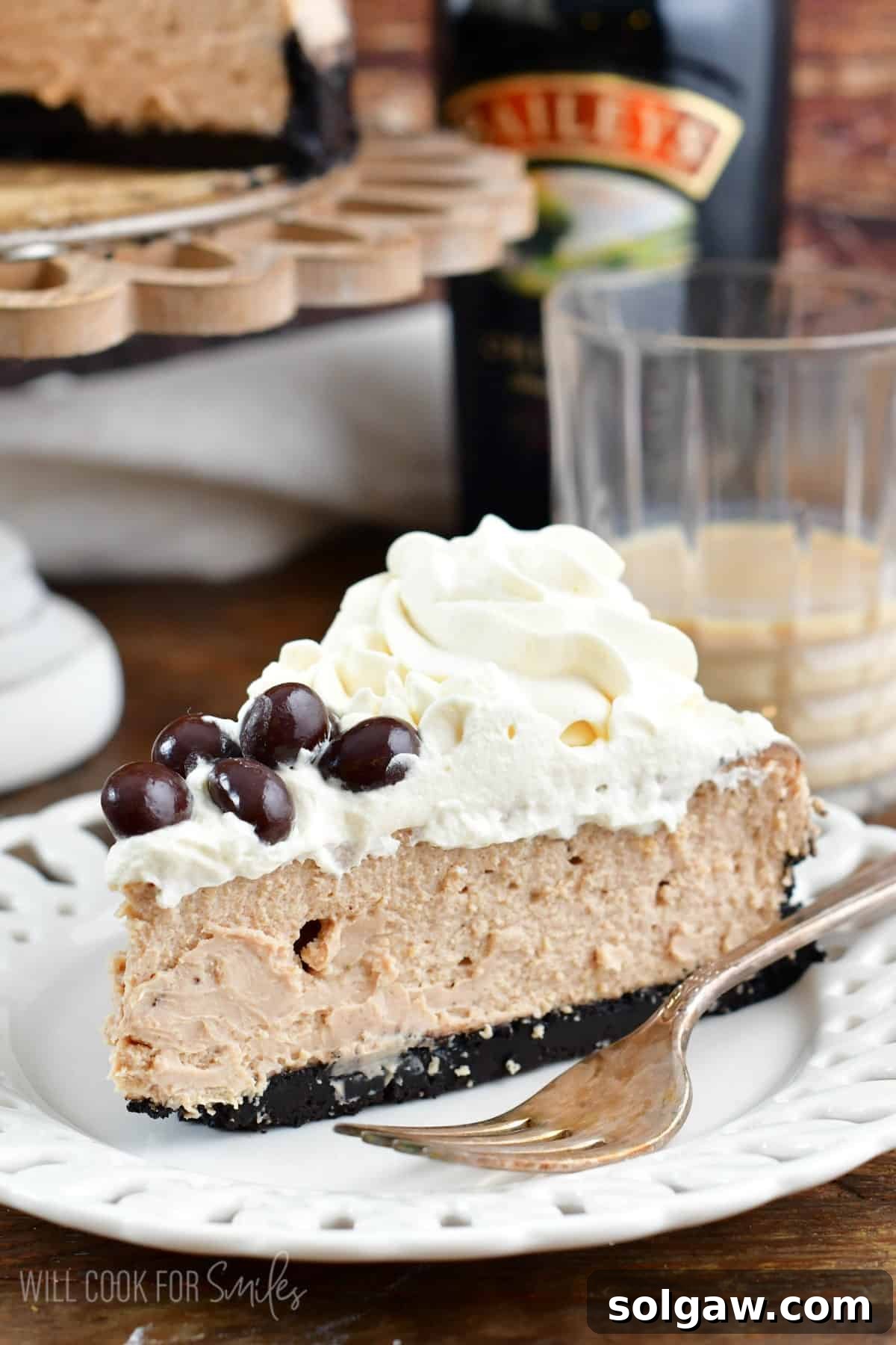 a slice of Bailey's cheesecake on a white plate with a fork.