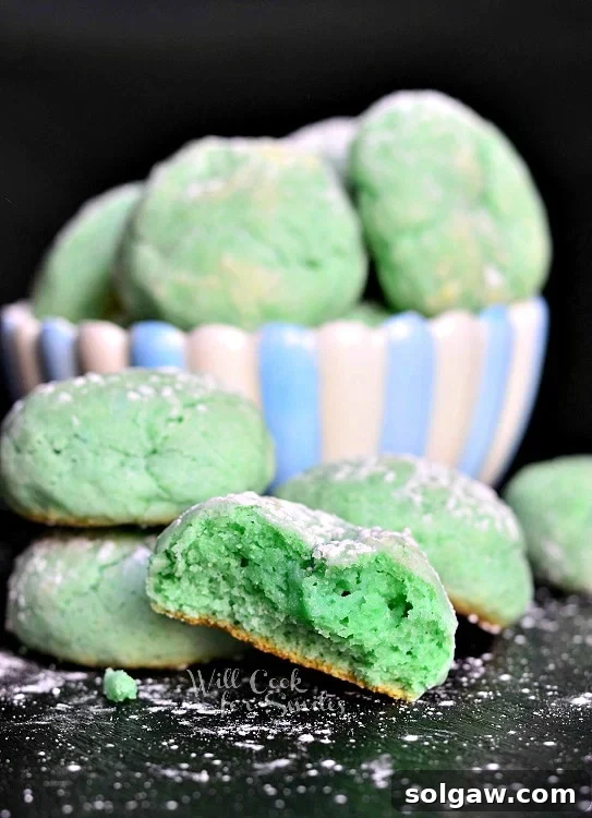 Cotton Candy Cloud Cookies 6 green cotton Candy Cookies on a black counter top with a bowl of cotton candy cookies in the background