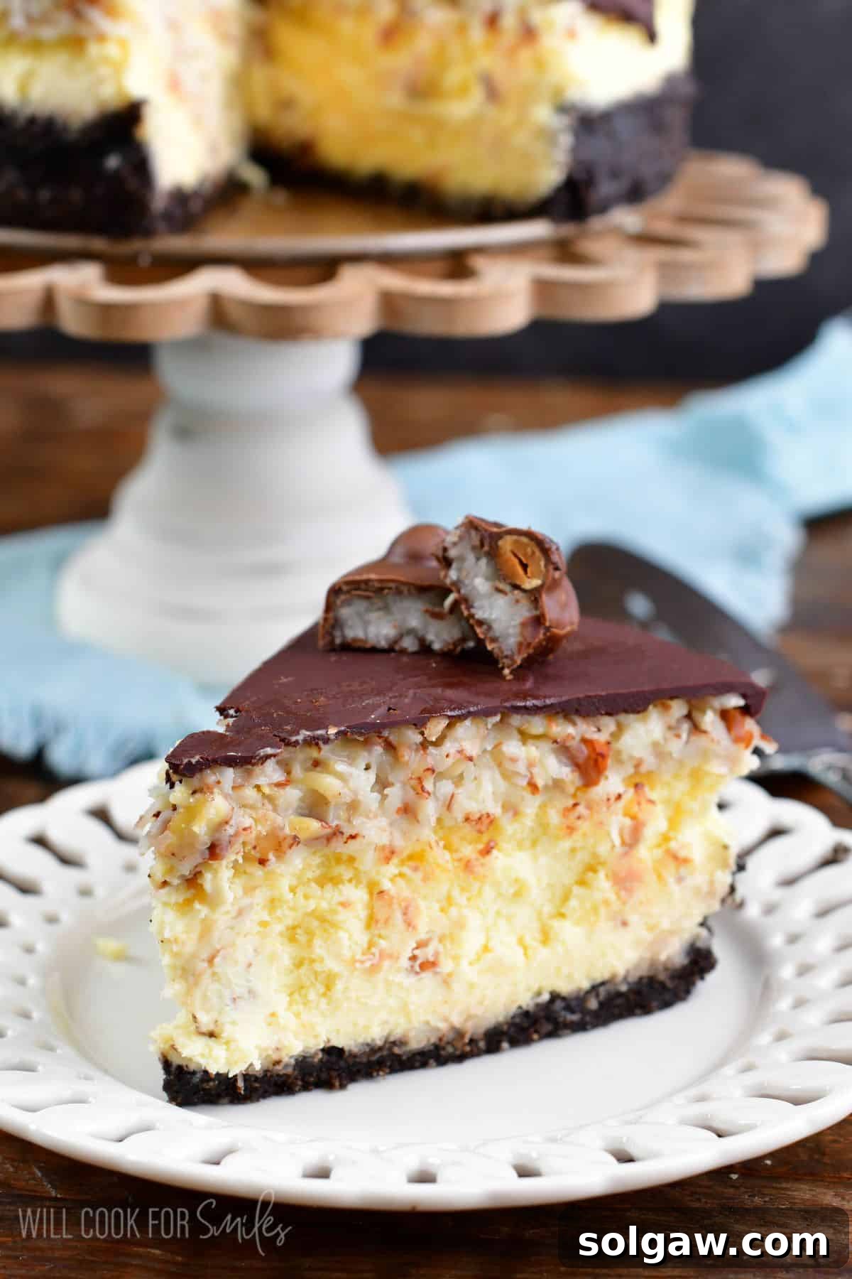 A slice of almond joy cheesecake on a plate, showing its layers.