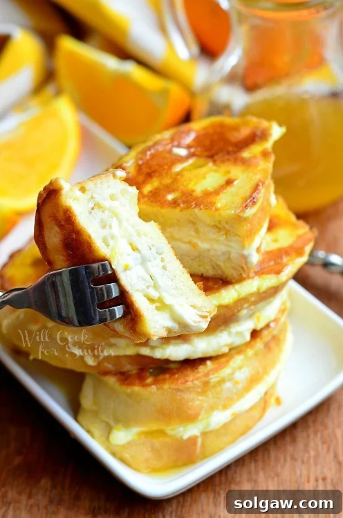 Orange Creamsicle French Toast sliced in half on a white plate