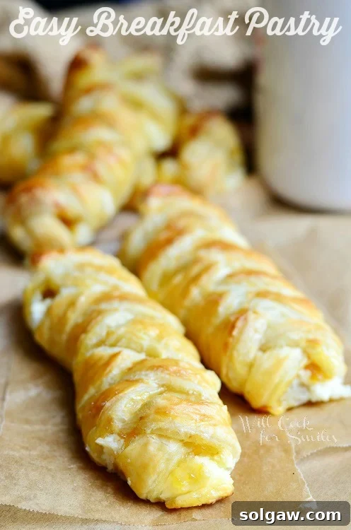 Delicious braided breakfast pastry on brown wax paper, ready to be enjoyed with coffee.