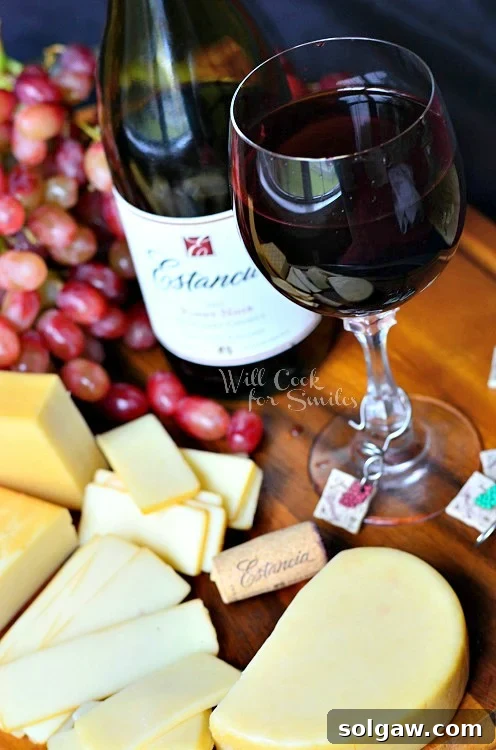Elegant wine and cheese platter featuring an assortment of cheeses, grapes, and crackers