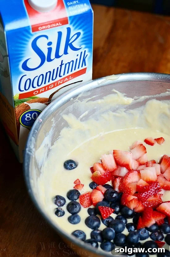 batter for berry bread with blue berries and strawberries in it