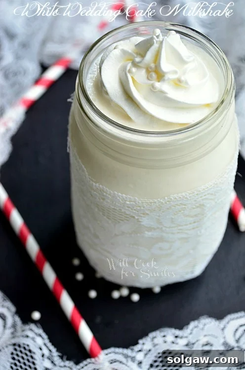 White Wedding Cake Milkshake in a mason jar with lace around it 